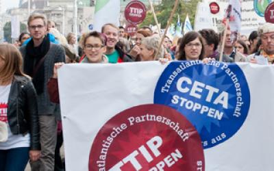Menschen bei der TTIP Demo 2014 mit Banner auf dem "TTIP Stoppen" und "CETA Stoppen" steht